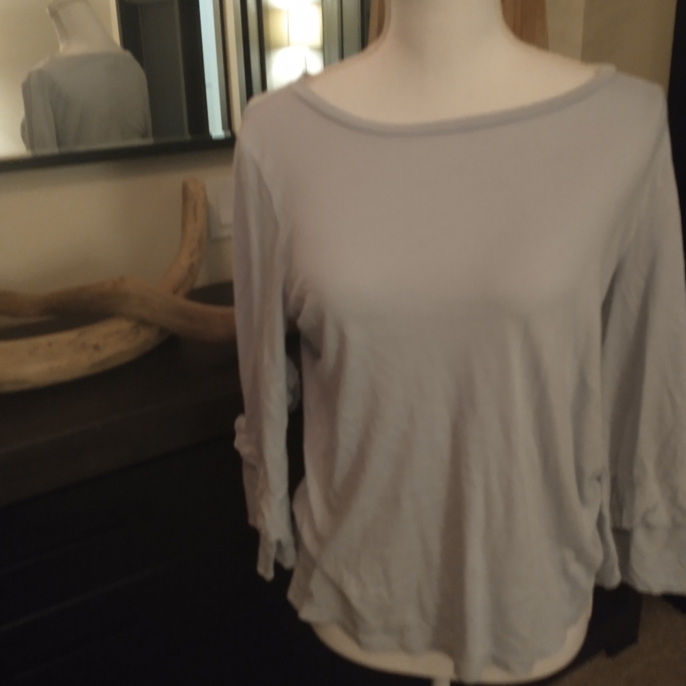 Sheer light blue top w/ ruffle on the arm.…